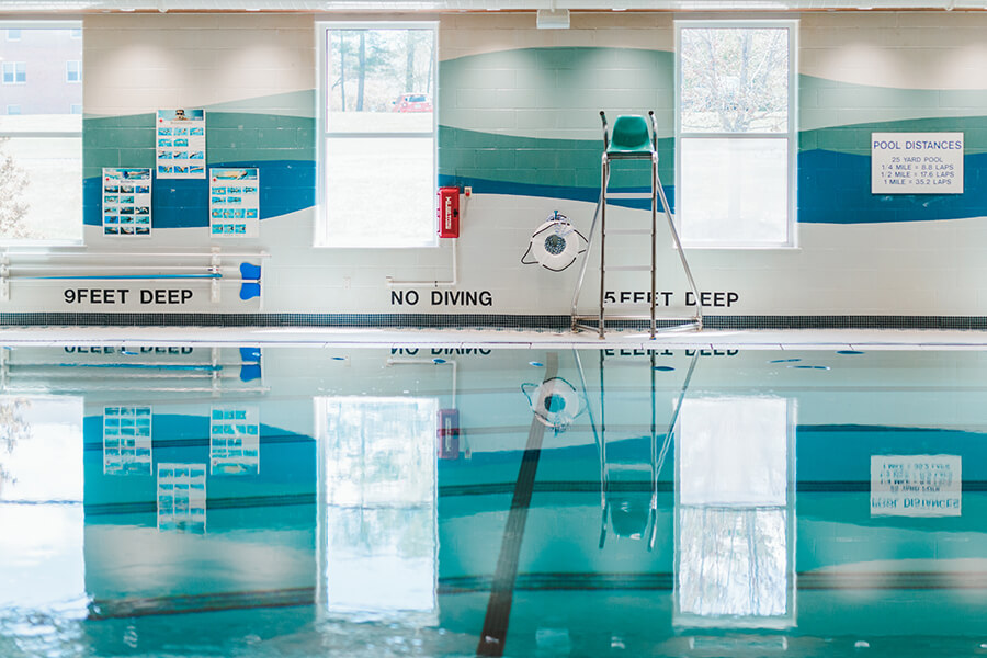 CP-pool The indoor swimming pool features clear water, a lifeguard chair, a wall mural with safety information, and "No Diving" signs. It's an ideal location for community programs, offering both recreation and education in our safe and well-maintained facility. Saint Joseph's College of Maine