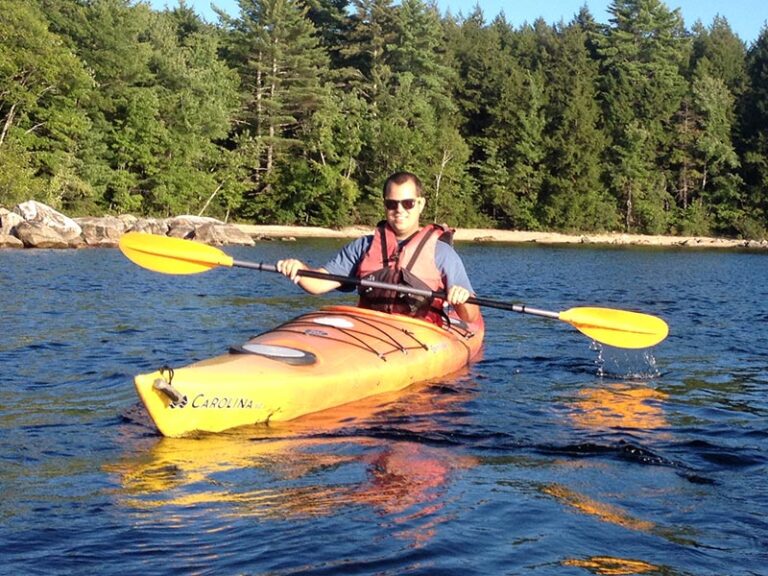 outdoor-adventure-club student kayaks on Sebago Lake