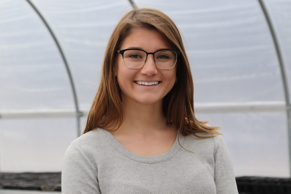 Hayley poses in the hoop house on campus.