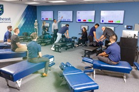 Saint Joseph’s College and Northeast College of Health Sciences Renew Articulation Agreement for Doctor of Chiropractic Program, Expand to Include Sciences Department 2 A group of individuals participate in a chiropractic training session at Saint Joseph’s College. Trainers from the Sciences Department demonstrate techniques on chiropractic tables, while others observe monitors displaying data as part of the Doctor of Chiropractic Program. Saint Joseph's College of Maine