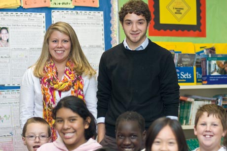 2 elementary education students pose with elementary school class