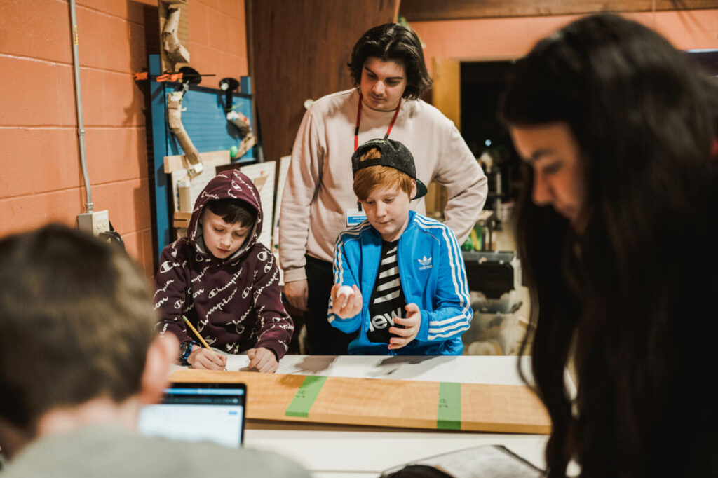 school children work with education students in the pollinator garden