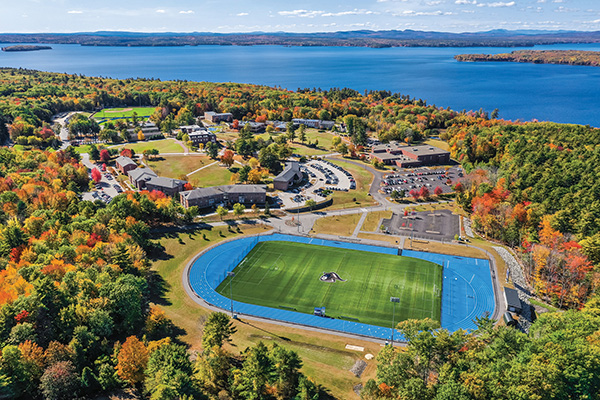 drone shot in fall of campus showing the athletic turf field