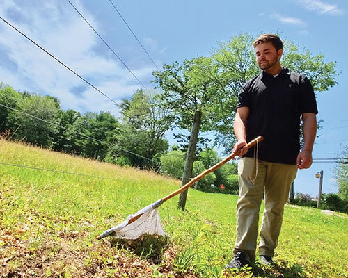 student Erick Schadler in the field researching ticks