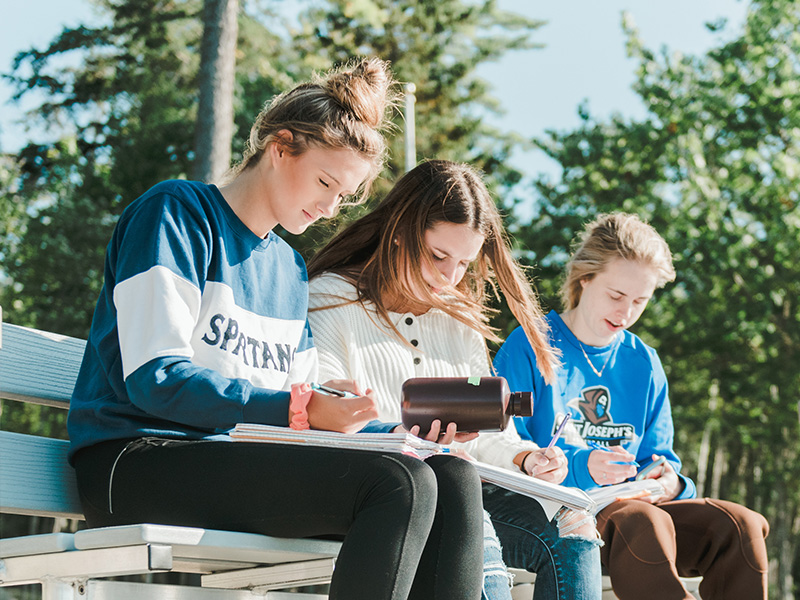 science students sit on the dock on campus