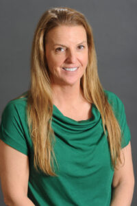 Counseling Center 2 A woman with long, light brown hair wearing a green short-sleeved top, smiling in front of a plain gray background. Saint Joseph's College of Maine