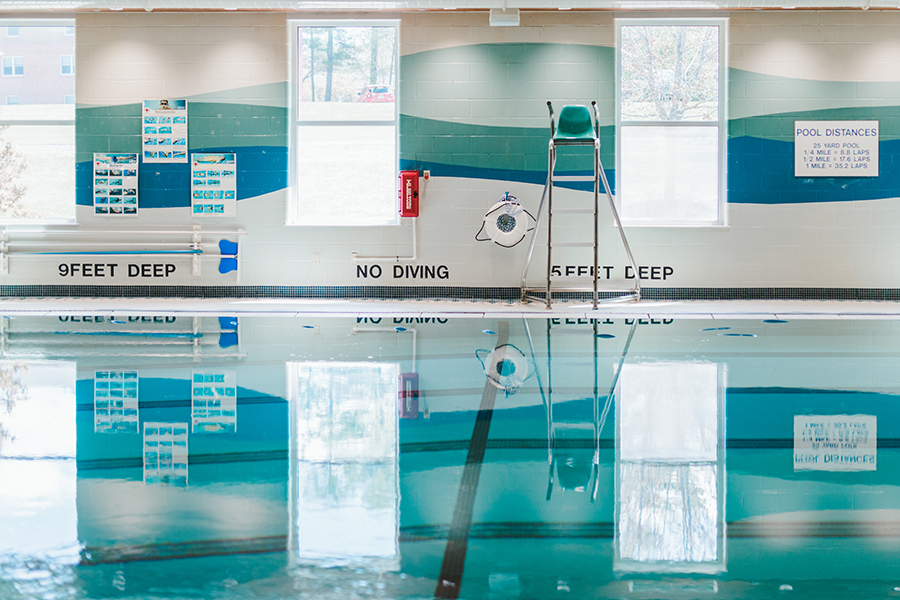 Cp-Pool The indoor swimming pool features clear water, a lifeguard chair, a wall mural with safety information, and "No Diving" signs. It's an ideal location for community programs, offering both recreation and education in our safe and well-maintained facility. Saint Joseph's College of Maine