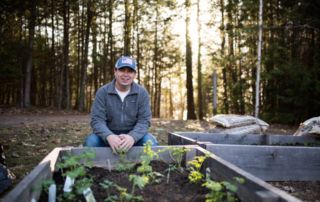Caleb Gravel at the bee pollinator garden at Saint Joseph's College of Maine