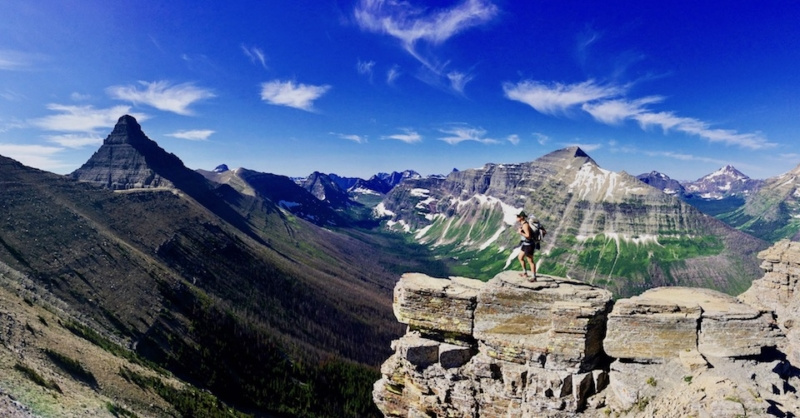 Effie stands on a mountaintop with a beautiful vista