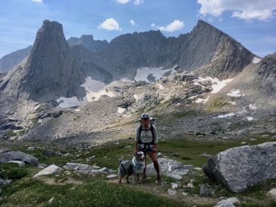 Effie poses with her dog Luna in front of a large glacial field.