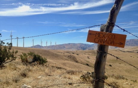 A sign points to Canada and Mexico with mountainous terrain in the background