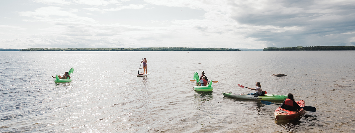 Students having fun in the water at the lakefront of Saint Joseph's College of Maine.