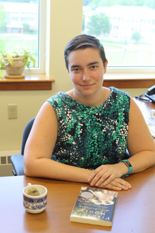 Lindsay Gibson poses at her desk with tea and a book