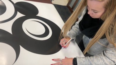 Madigan Cogger prepares her graphic design for exhibition