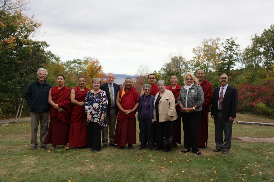 Members of the Center for Faith and Spirituality planning committee stand with Monks in front of Sebago Lake.
