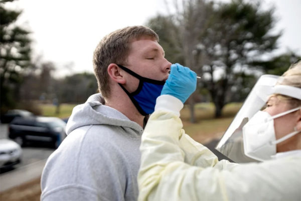 Photo taken by Brianna Soukup of the Portland Press Herald of SJC's health director testing student for covid-19 before sending students home to finish out the semester.