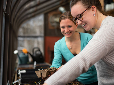 Education student and Patricia Waters grow seedlings for a science curriculum for community-based learning