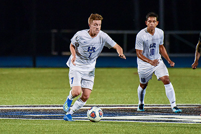 Men's soccer team plays on the turf field