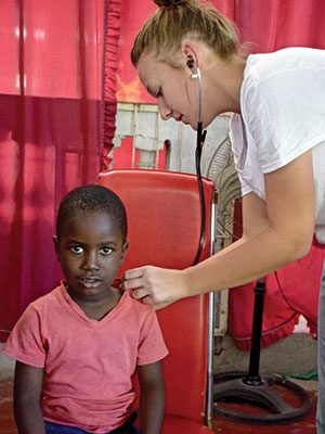 Sjc Nursing Student Providing Medical Exam On A Haitian Child SJC nursing student providing medical exam on a Haitian child