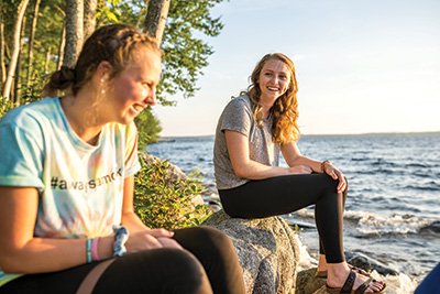 Saint Joseph's College of Maine students sitting at the lakefront